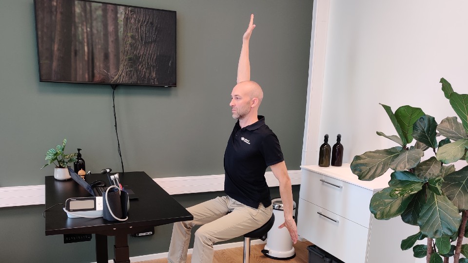 Osteopat Jeppe Bjerre Smed fra Billund Osteopati viser windmill øvelse.